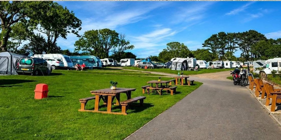 Picnic benches on the campsite lawn — pull up a seat.